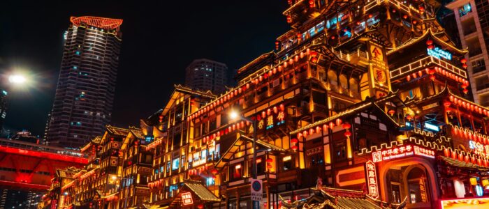 Vibrant view of Hongya Cave in Chongqing, China lit up at night, showcasing traditional Chinese architecture.
